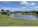 Scenic view of a community pond with a water fountain, surrounded by lush green lawns at 13100 S Mccall Rd # 125, Port Charlotte, FL 33981