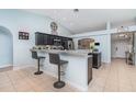 Spacious kitchen featuring dark cabinets, granite countertops, and a convenient breakfast bar for casual dining at 1444 Frisco Ter, Port Charlotte, FL 33953