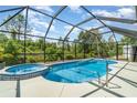 Inviting screened-in pool area with a relaxing spa, perfect for outdoor enjoyment and entertaining guests at 1444 Frisco Ter, Port Charlotte, FL 33953