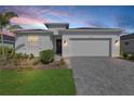 Charming home with a neatly landscaped front yard and a paver driveway leading to a two-car garage at 15069 Anchorage Rd, Punta Gorda, FL 33982
