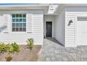 Close up of the home's exterior showcasing the front door, window, and a beautifully landscaped front yard at 15069 Anchorage Rd, Punta Gorda, FL 33982