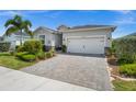 Beautiful single-story home showcasing a paver driveway, two-car garage, and lush landscaping at 16176 Lotus Way, Punta Gorda, FL 33982