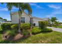 Attractive single-story home featuring a well-maintained lawn and landscape with mature palm trees at 16176 Lotus Way, Punta Gorda, FL 33982