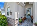 Cozy front porch featuring a bench, decorative pillows, stylish rug, and light blue front door at 16176 Lotus Way, Punta Gorda, FL 33982