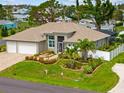 Well-maintained single-story home with lush landscaping, a three-car garage, and a charming front seating area at 1721 Walden Ct, Englewood, FL 34224