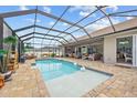Screened-in pool area with stone pavers, swan decoration, and comfortable seating perfect for outdoor relaxation at 1721 Walden Ct, Englewood, FL 34224
