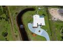 Aerial view showcases the stunning home with a long private driveway, waterway feature, and screened in pool at 17400 White Water Ct, Punta Gorda, FL 33982