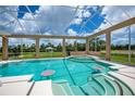 Inviting screened-in pool area with in-pool seating and scenic views of the surrounding landscape at 17400 White Water Ct, Punta Gorda, FL 33982