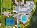 Aerial view of the community clubhouse featuring a swimming pool, tennis courts, and ample parking at 1812 Birmingham Blvd, Punta Gorda, FL 33980