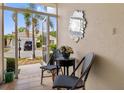 Inviting front patio seating area with tiled floor, decor mirror and beautiful views of the landscaped front yard at 1812 Birmingham Blvd, Punta Gorda, FL 33980