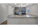 Modern kitchen with granite counters, stainless steel appliances, gray cabinets, and a stylish light fixture at 2101 W Cherry St, Tampa, FL 33607