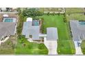 Aerial view of a property with a pool, spacious lawn, and detached two-car garage at 23493 Taber Ave, Port Charlotte, FL 33954