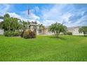 Beautiful single-story home with a manicured front lawn, mature palm trees, and an American flag at 23493 Taber Ave, Port Charlotte, FL 33954