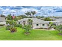 Charming single-story home featuring a well-maintained lawn, beautiful landscaping, and an American flag at 23493 Taber Ave, Port Charlotte, FL 33954