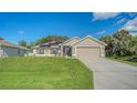 Charming single-Gathering home boasts solar panels, a two-car garage, and a lush front lawn at 237 Strasburg Dr, Port Charlotte, FL 33954