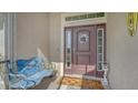 Welcoming front door with sidelights and a transom window, complemented by a charming bench at 237 Strasburg Dr, Port Charlotte, FL 33954
