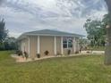 Single-story home on a green lawn features contemporary architecture, manicured landscaping, and large windows at 26129 Madras Ct, Punta Gorda, FL 33983
