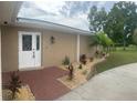 Inviting home featuring a brick walkway, lush landscaping, and a classic double door entry at 26129 Madras Ct, Punta Gorda, FL 33983