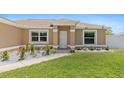 Charming front entrance with a well-kept lawn, decorative plants, and a welcoming front door at 3138 Darius Ave, North Port, FL 34288