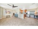 Open-concept living area showcasing tile flooring, a ceiling fan, and seamless flow to the modern kitchen at 3171 Highlands Rd, Punta Gorda, FL 33983