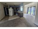 Kitchen with white refrigerator, stainless steel sink, dark cabinets and sliding glass door to the exterior at 4424 Baroda Ave, North Port, FL 34287