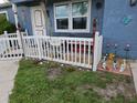 Inviting home exterior showcases a tidy lawn, charming white picket fence, and colorful garden decorations on the front porch at 4583 S Salford Blvd, North Port, FL 34287