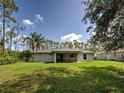 Lush backyard with manicured lawn, mature trees, and a view of neighboring properties, offering a peaceful outdoor space at 4609 Jaslo Ave, North Port, FL 34286