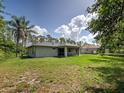 A spacious backyard features a lush lawn and mature trees, creating a private outdoor retreat at 4609 Jaslo Ave, North Port, FL 34286