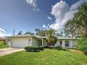 Single-story home with attached two-car garage, lovely landscaping, and a well maintained lawn at 4609 Jaslo Ave, North Port, FL 34286