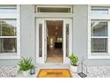 Inviting front entrance with an open door, plants, and a 'Welcome' mat at 5436 Jessamine Ave, North Port, FL 34291