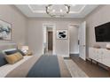 Cozy main bedroom with a decorative chandelier, hardwood floors, and access to a ensuite bathroom at 5451 Prime Ter, North Port, FL 34286