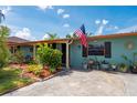 A charming home with a colorful facade and beautifully landscaped front yard with a quaint seating area at 611 Bonita Ct, Punta Gorda, FL 33950