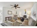 Cozy living room with neutral colors, ceiling fan, comfortable seating, and natural light at 6764 Stardust Ave, North Port, FL 34287