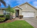 Close-up of a well-maintained home entrance with landscaped yard, decorative plants, and attached two-car garage at 7292 Mikasa Dr, Punta Gorda, FL 33950