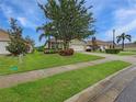 Beautifully landscaped front yard with lush green grass, mature trees, and decorative shrubs enhancing curb appeal at 7292 Mikasa Dr, Punta Gorda, FL 33950