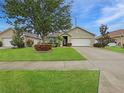 Charming home with a well-manicured lawn, mature trees, and colorful landscaping enhancing its curb appeal at 7292 Mikasa Dr, Punta Gorda, FL 33950