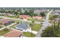 An aerial view showcases the neighborhood, nearby streets, landscaping, and architectural details of the house at 1007 Comstock St, Port Charlotte, FL 33952