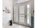 Bright foyer featuring tile flooring, and white doors with windows and shutters that let in natural light at 1007 Comstock St, Port Charlotte, FL 33952