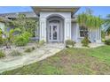 Inviting entryway with decorative glass door, stone walkway, manicured landscaping and neutral paint scheme at 1007 Comstock St, Port Charlotte, FL 33952