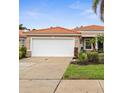 Inviting single-story home featuring a red tile roof, a two-car garage, and lush front yard at 10316 Hebblewhite, Englewood, FL 34223