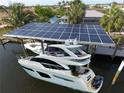 Aerial view of boat dock with solar panels, shading boat and providing sustainable energy at 107 Sinclair Se St, Port Charlotte, FL 33952