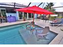 Inviting screened-in pool area with underwater seating, perfect for relaxing and entertaining outdoors at 107 Sinclair Se St, Port Charlotte, FL 33952