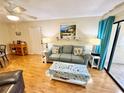 Bright living room boasting hardwood floors, a comfy couch, and sliding glass door access to outdoor space at 1515 Forrest Nelson Blvd # D102, Port Charlotte, FL 33952