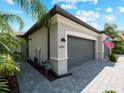 Two car garage with gray doors and paver driveway at 15974 Clear Skies Pl, Bradenton, FL 34211