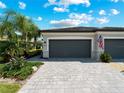 Two car garage with gray doors and paver driveway at 15974 Clear Skies Pl, Bradenton, FL 34211