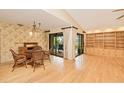 Dining room with light hardwood floors and large sliding doors overlooking the pool at 2160 Aqui Esta Dr, Punta Gorda, FL 33950
