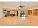 Spacious living room featuring hardwood floors, built-in bookshelves, and backyard access at 2160 Aqui Esta Dr, Punta Gorda, FL 33950