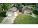 An aerial view of the single Gathering home, driveway, and lawn at 23273 Abeline Ave, Punta Gorda, FL 33980