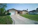 Single Gathering home with a long driveway, attached garage and manicured lawn at 23273 Abeline Ave, Punta Gorda, FL 33980