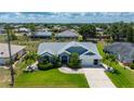 Expansive aerial view of the home with lush landscaping, manicured lawn, and sparkling pool surrounded by a serene neighborhood at 25371 Paladin Ln, Punta Gorda, FL 33983